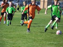 Austin in the green with the red hair.  O.K. he is the one kicking the ball with the red hair.