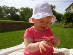 Miss C and her first real flower a petunia one that I planted.
